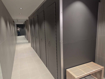 The private stalls in the all gender washroom. Mirror at end.