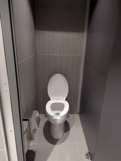 One of five private stalls within the all gender washroom with floor to ceiling doors.